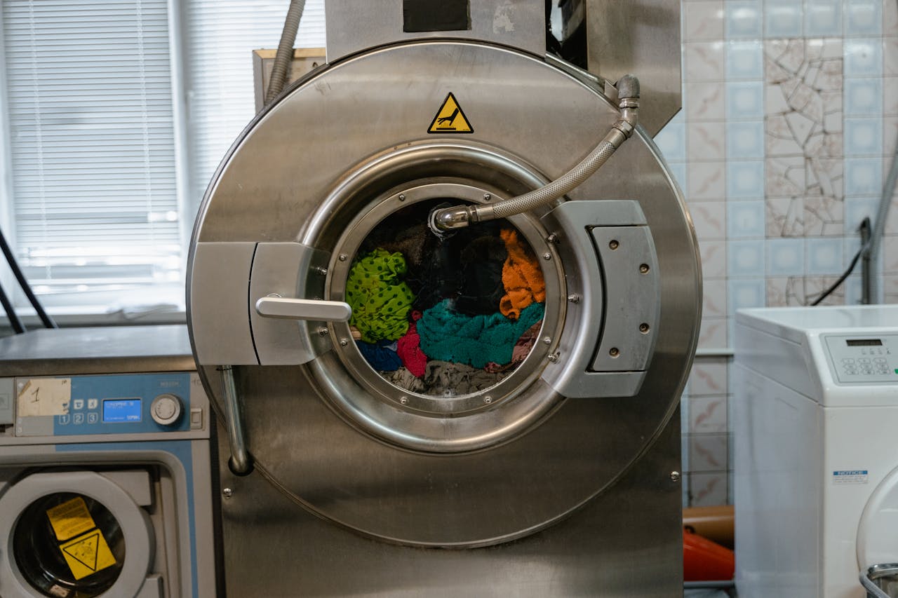 A close-up of an industrial washing machine operating in a laundry facility.